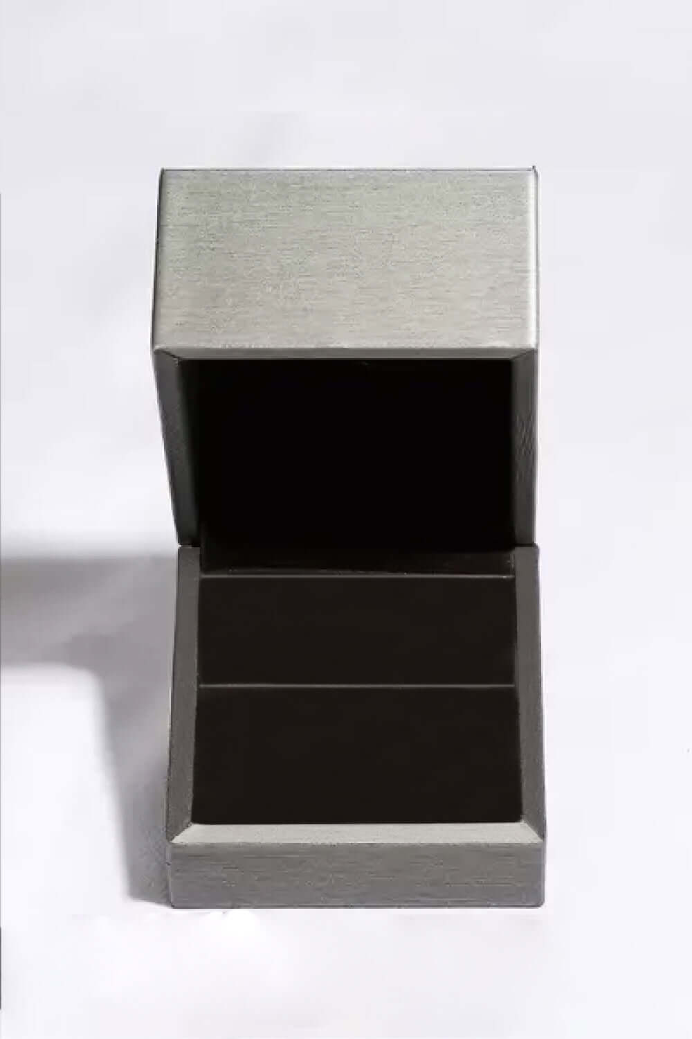 Open jewelry box with a metallic finish, featuring an empty interior, perfect for displaying earrings or small accessories.