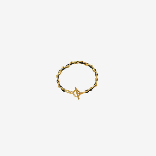 18K gold-plated leather chain bracelet with titanium steel accents, featuring a sleek design and toggle clasp on a cream background.