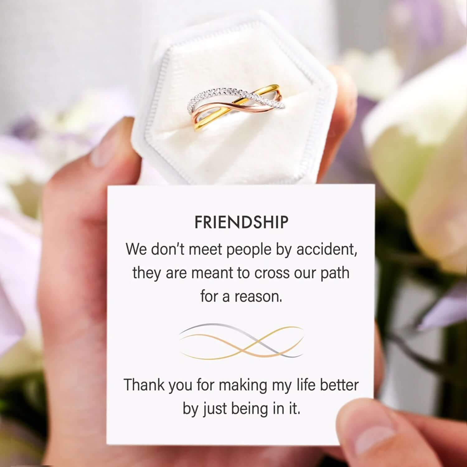 Crisscross gold-plated 925 sterling silver ring in box with friendship message in background.