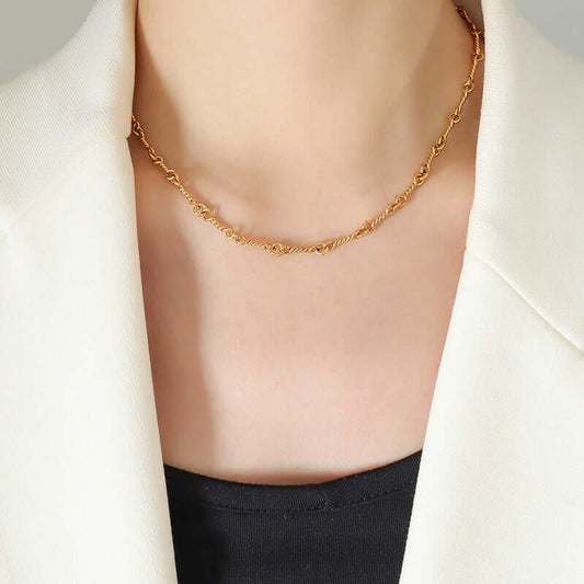 Elegant 18K gold-plated titanium steel chain link necklace worn with a white blazer.