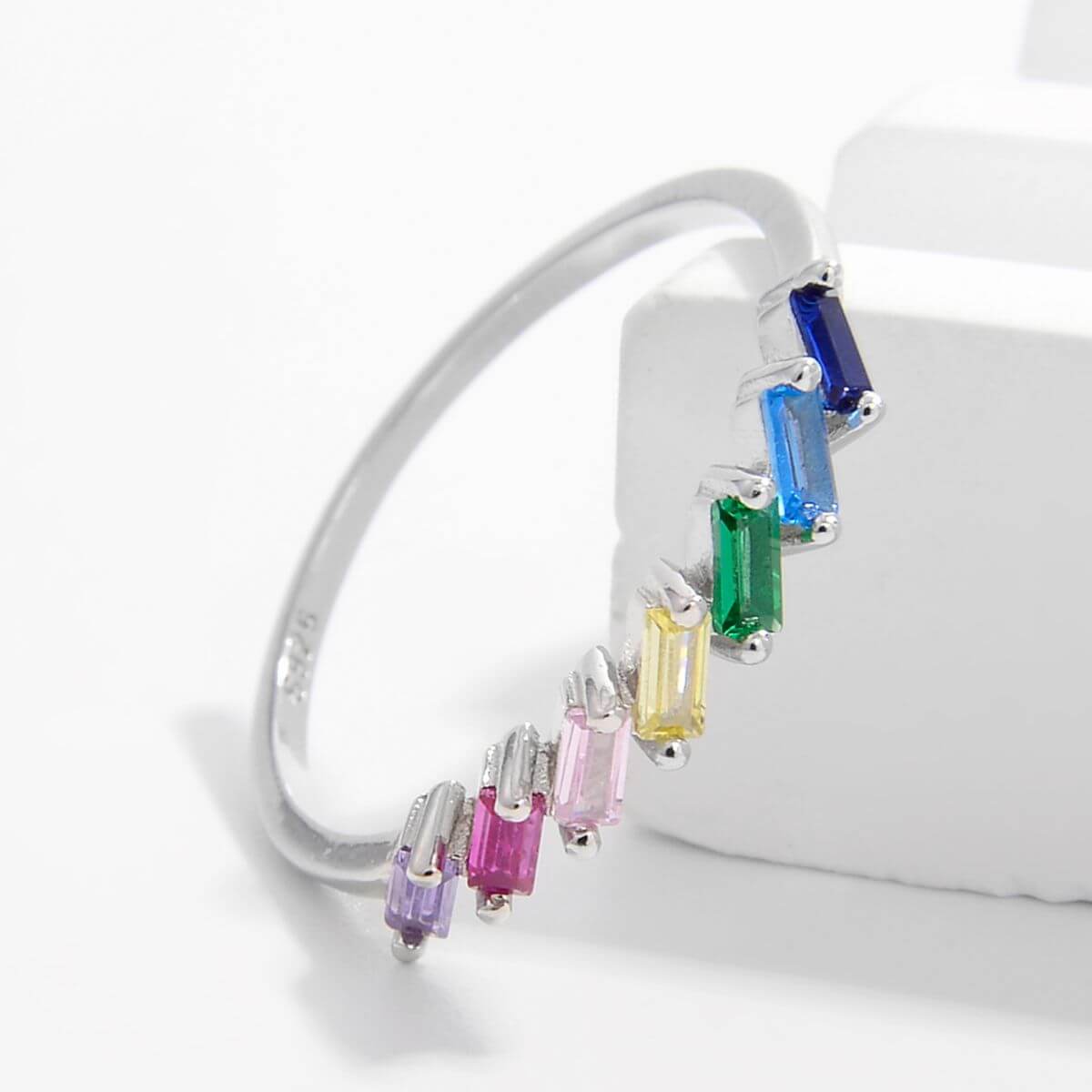 Elegant bracelet with rainbow-colored zircon stones set in platinum-plated 925 sterling silver, displayed on a white background.