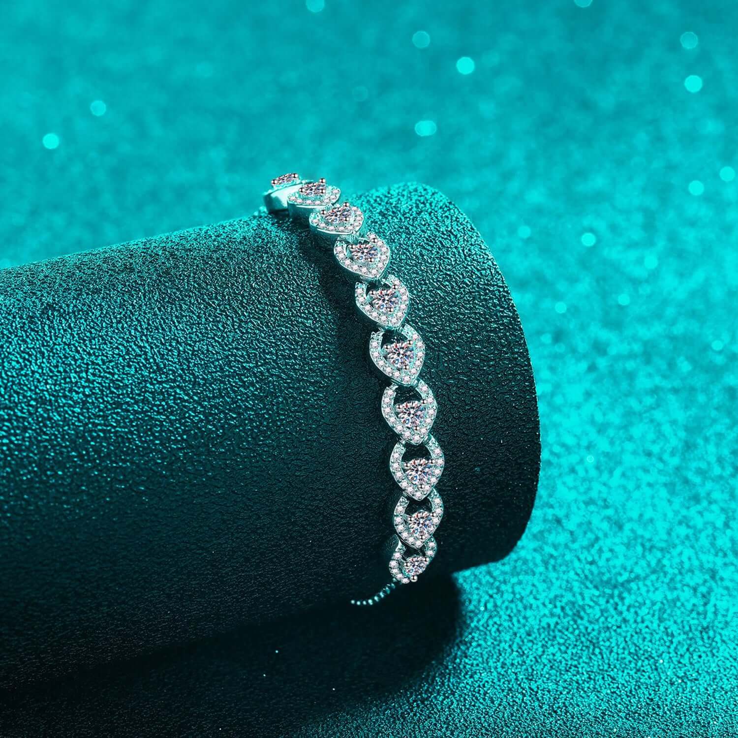 Elegant 1 carat moissanite bracelet in 925 sterling silver on display with teal background.