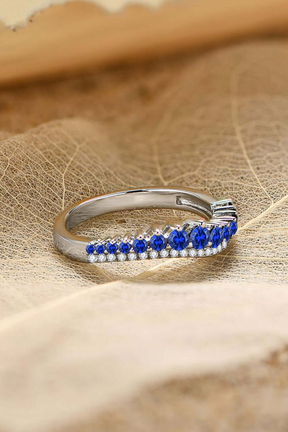 Minimalist lab-grown sapphire ring in 925 sterling silver with platinum plating displayed on textured background.