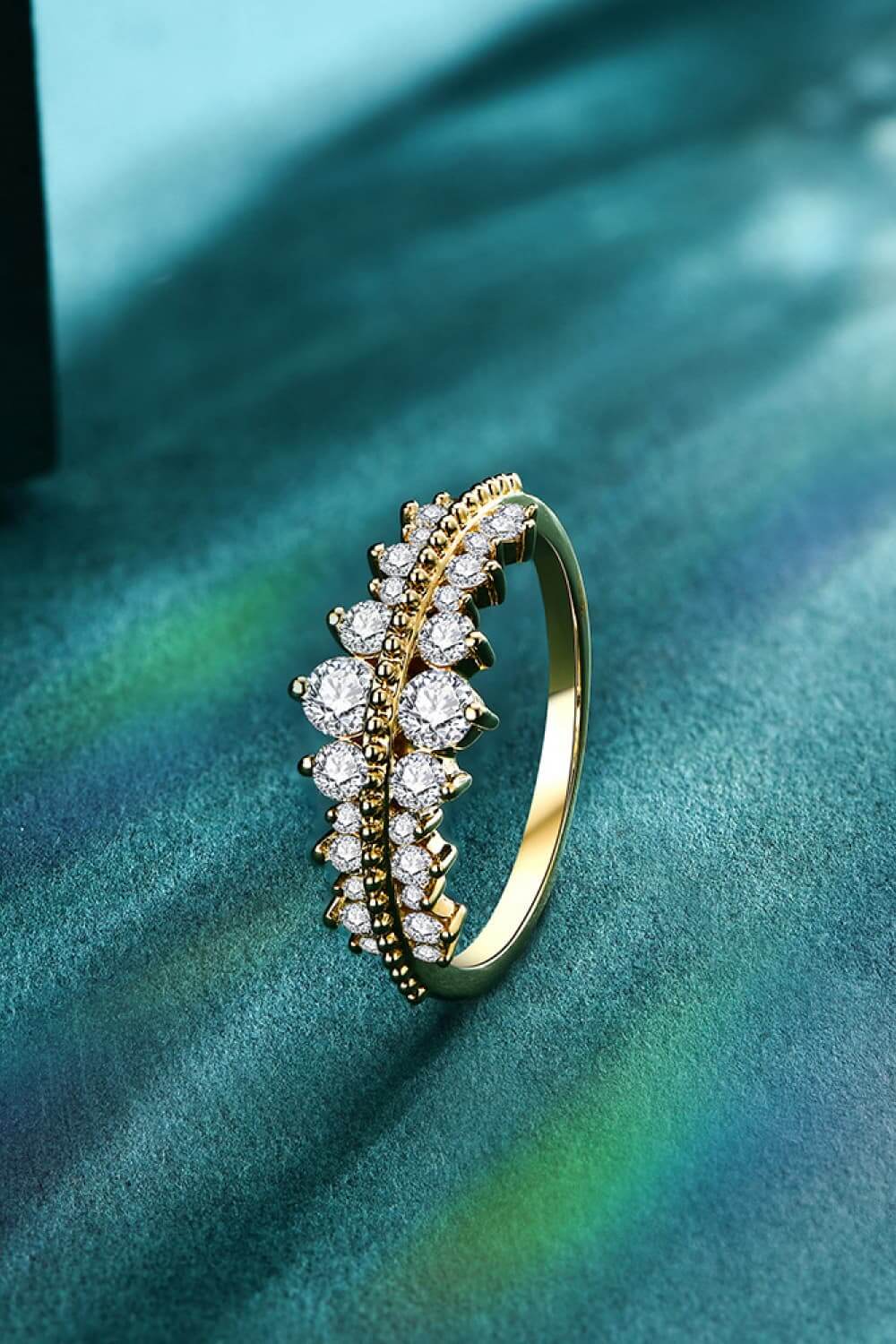 Moissanite 925 sterling silver ring with 18K gold plating, minimalist design, displayed on a textured background.