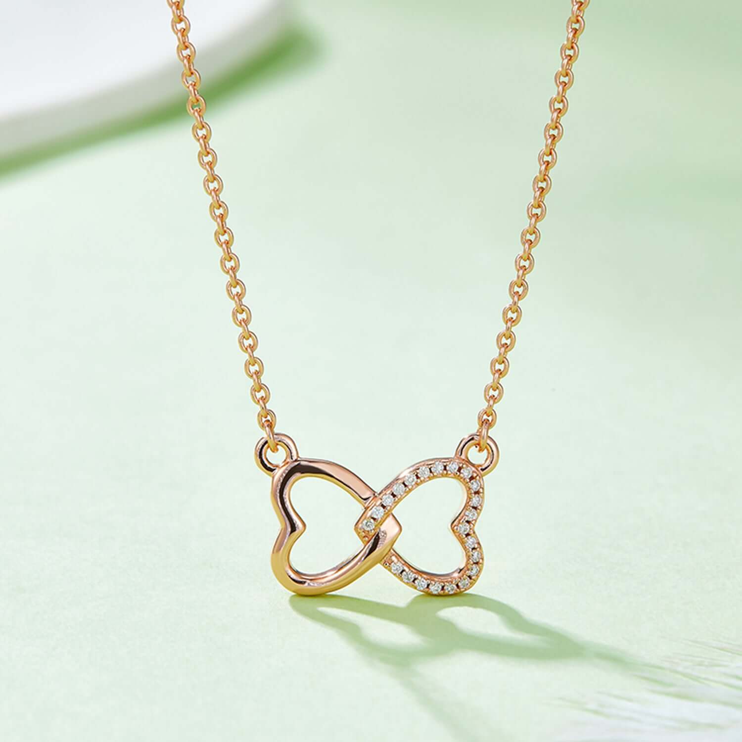 Moissanite 925 Sterling Silver Heart Bow Necklace with intertwined heart design on a delicate chain, rose and gold-plated finish.