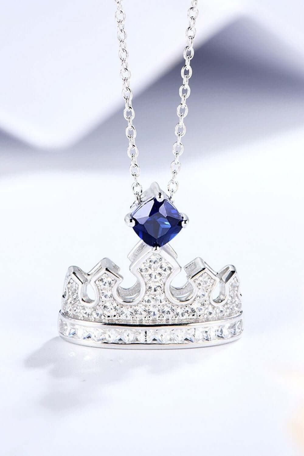 Zircon lab-grown sapphire crown shape pendant necklace in platinum-plated 925 sterling silver on minimalist chain.