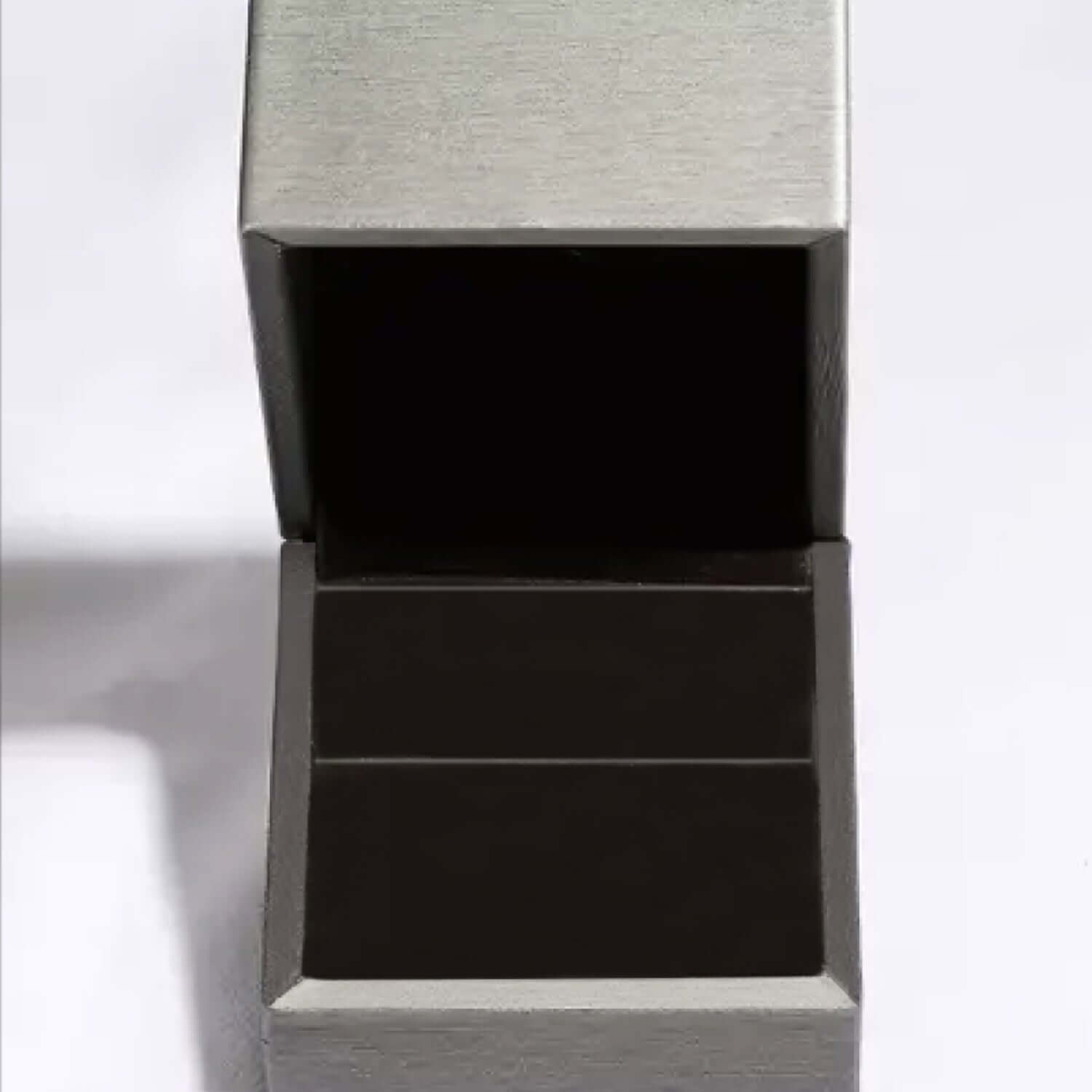 Open gray jewelry box with a black interior, designed to hold a ring or small piece of jewelry.