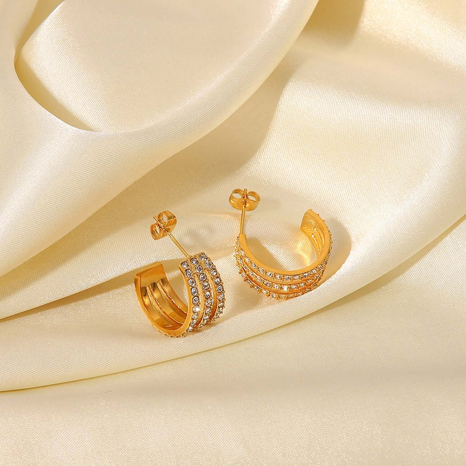 Stainless Steel Inlaid Zircon C-Hoop Earrings with Gold-Plated Finish on Satin Fabric Background