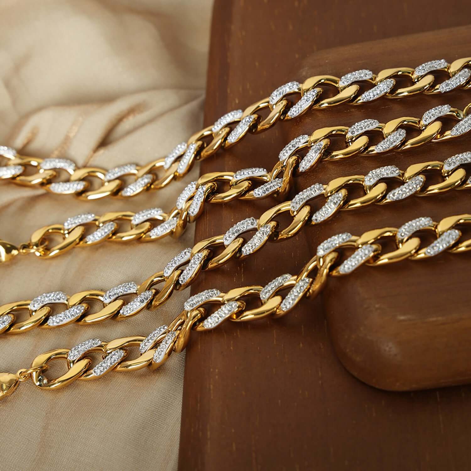 Gold-plated zircon titanium steel chunky chain necklace displayed on fabric and wood background.