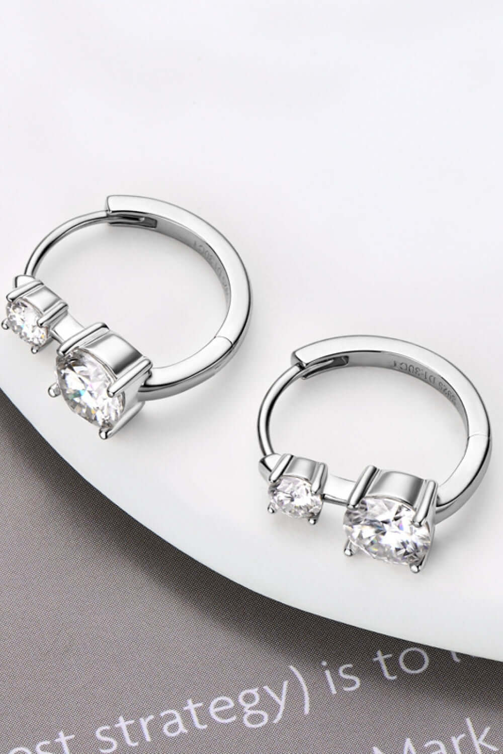 1.3 carat moissanite sterling silver earrings on display, featuring platinum and rose gold plating with a stylish design.