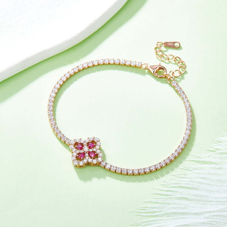 Lab-grown ruby and zircon flower shape bracelet in 925 sterling silver with 18K rose gold plating on green background.