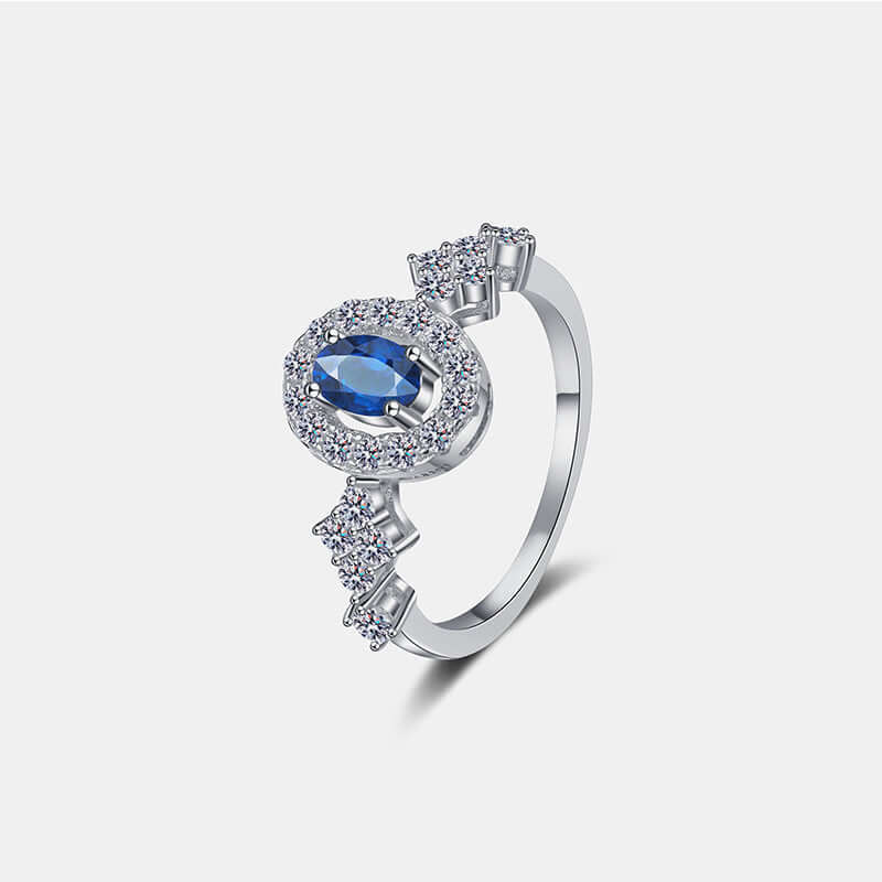 Elegant 925 sterling silver ring with blue gemstone and sparkling accents, featuring a halo and band design. Perfect for special occasions.