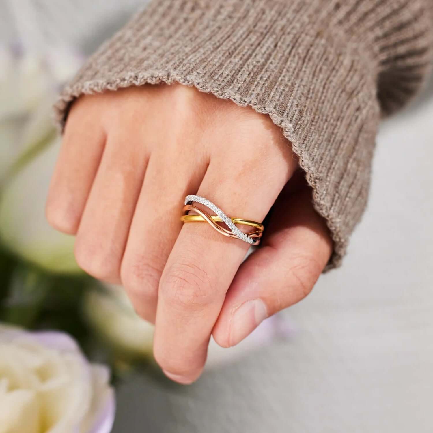 Crisscross 18K gold-plated 925 sterling silver ring on hand, showcasing elegant design and rose gold accents. Perfect for daily wear.