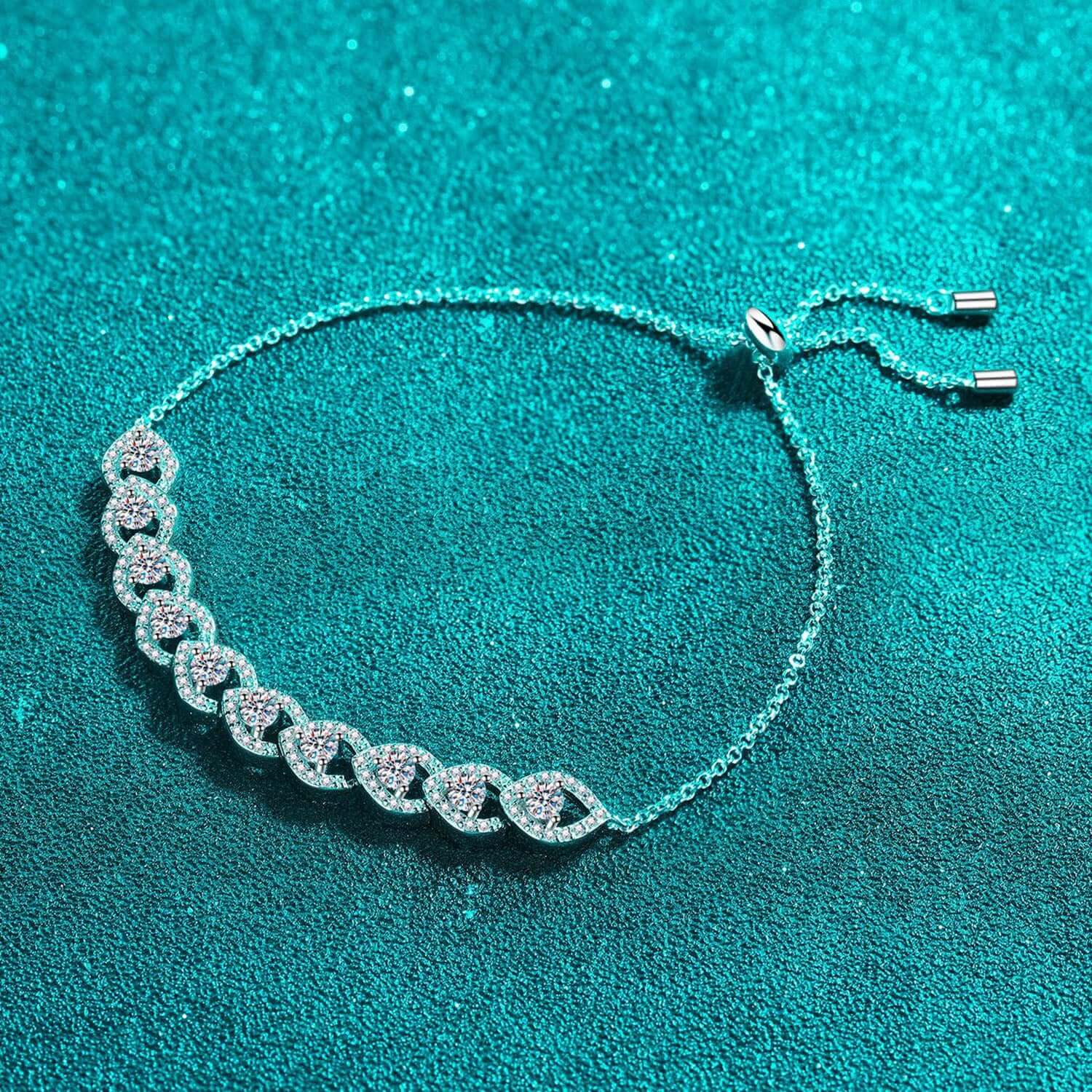 1 Carat Moissanite 925 Sterling Silver Bracelet on teal fabric background, featuring elegant chain design and sparkling stones.