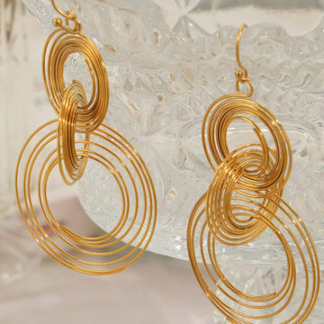 Titanium steel gold-plated multi-layered round shape earrings displayed against a glass background.