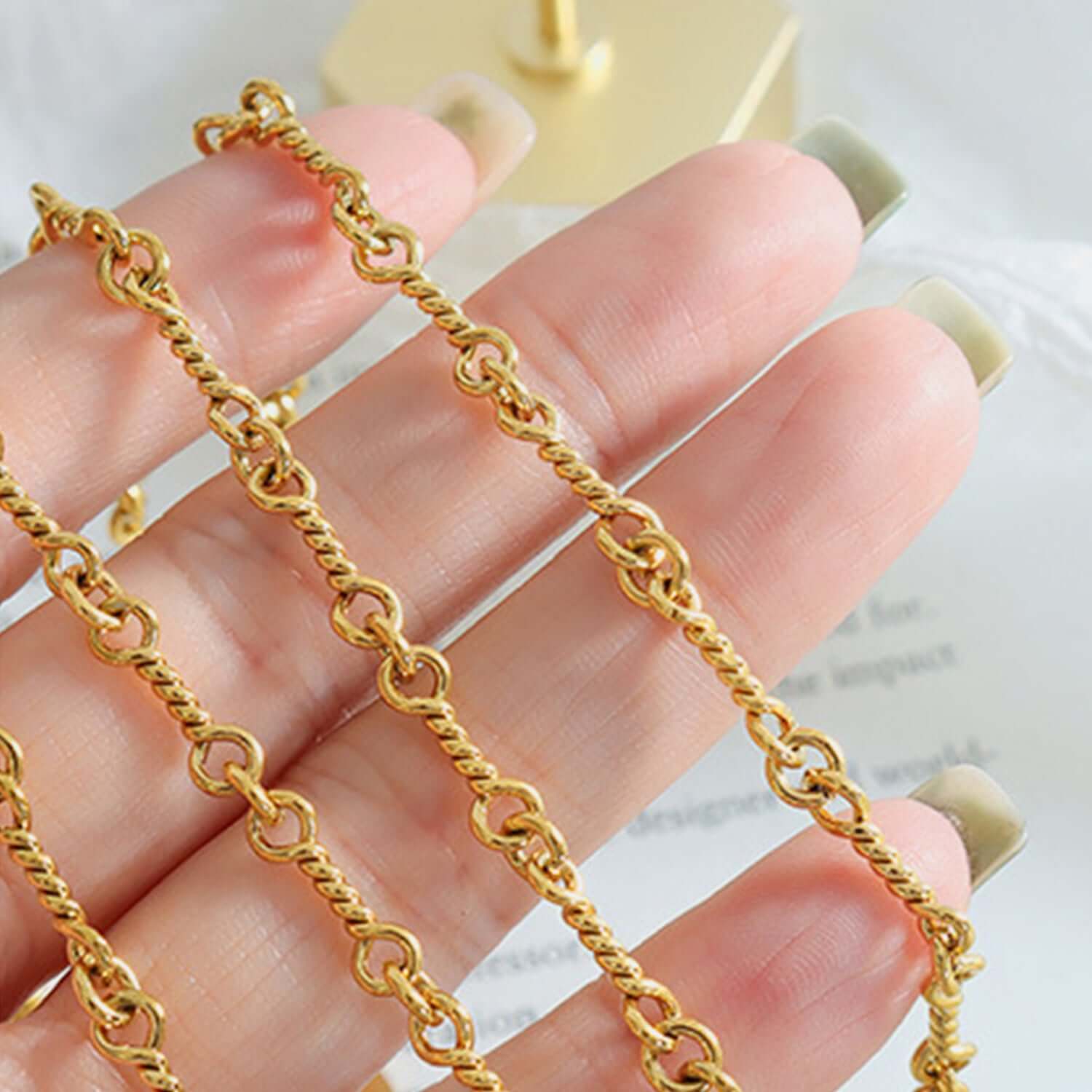 Gold-plated titanium steel chain link necklace displayed on hand, showcasing intricate design and craftsmanship.